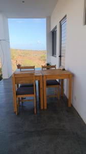 drewniany stół i krzesła z widokiem na pustynię w obiekcie BEM VINDOS A KASA w mieście Porto Novo