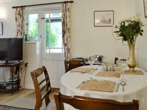 un comedor con una mesa con un jarrón de flores en The Coach House, en Southampton