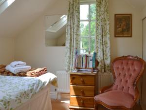 1 dormitorio con 1 cama, 1 silla y 1 ventana en The Coach House, en Southampton