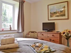 Dormitorio con bandeja de comida en la cama en Ty Newydd Cottage en Hoel-galed