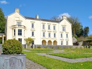 uma grande casa branca com um jardim em frente em Ty Newydd Cottage em Hoel-galed