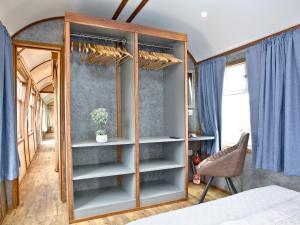 1 dormitorio con armario con espejo y silla en Brunel Boutique Railway Carriage 4, en Dawlish Warren