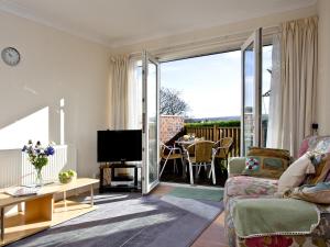uma sala de estar com um sofá e uma televisão em 1 Roundham Heights em Paignton