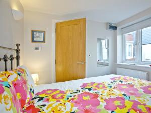 een slaapkamer met een bed met een bloemenbed bij Little Gem in Weymouth