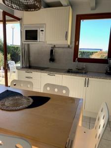 kuchnia ze stołem, krzesłami i kuchenką mikrofalową w obiekcie MAISON LANDES OCEAN w mieście Saint-Julien-en-Born