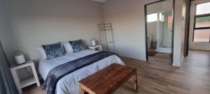 1 dormitorio con cama grande y mesa de madera en STEYNMOND COTTAGE en Kakamas