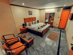 a bedroom with a bed and a table and a chair at Lexus Lodge in Islamabad