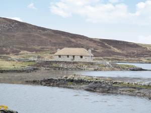 a building on an island in a body of water at Creagan Na Mara in Paible