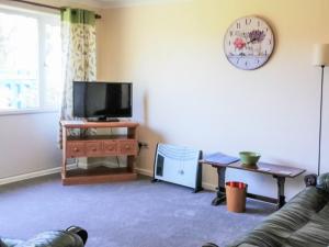 a living room with a couch and a tv at 2 The Paddocks in Happisburgh