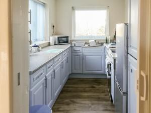 a kitchen with white cabinets and a white refrigerator at 2 The Paddocks in Happisburgh