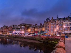 a city with buildings and a river at night at Captains Folly in Oban