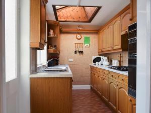 uma cozinha com armários de madeira e uma clarabóia em Alexandra Cottage em Windermere