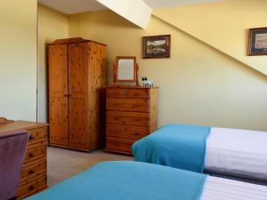1 dormitorio con 1 cama y vestidor con espejo en Alexandra Cottage, en Windermere