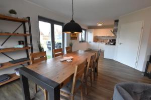 uma sala de jantar e cozinha com mesa e cadeiras de madeira em Ferienhaus Cappuccino auf der Insel Rügen em Lauterbach