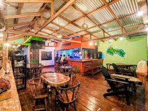 a restaurant with tables and chairs and a bar at Las Palmeras OceanView Hotel and Dive Center in Little Corn Island