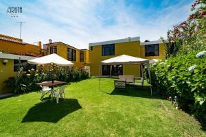 un jardín con mesa, sillas y sombrillas en Hotel La Gruta, en Arequipa