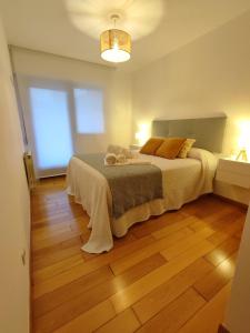 1 dormitorio con 1 cama y suelo de madera en A Xanela de Balneario, en Mondariz-Balneario