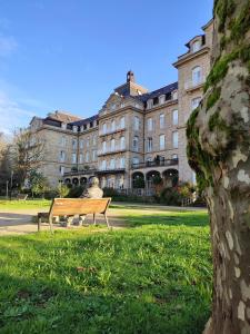 a person sitting on a bench in front of a building at A Xanela de Balneario in Mondariz-Balneario