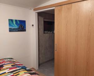 a bedroom with a wooden closet and a door at Apartment in the center in Húsavík