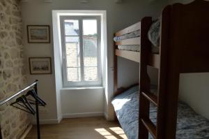 a bedroom with a bunk bed and a window at La maison de Jeanne in Pont-Croix