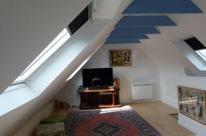 a room with a staircase with a tv and a rug at La maison de Jeanne in Pont-Croix