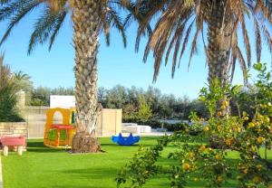 a yard with two palm trees and a playground at Leto 13 Villa in Paphos City