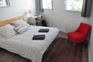 um quarto com uma cama e uma cadeira vermelha em Grand et lumineux apt. T2 à 2 pas de l'Erdre em Nantes