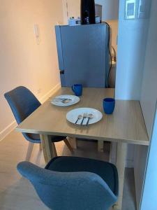 een tafel met blauwe stoelen en een bord erop bij Amenity View Studio Azure North in San Fernando