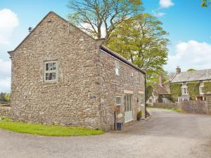 an old stone building with a tree behind it at The Granary - 26502 in High Etherley