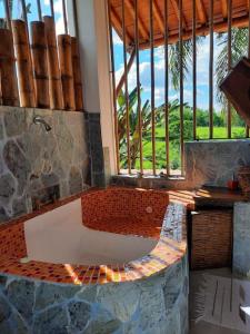 una vasca da bagno in una stanza con una grande finestra di Finca Turística La Casa que Canta a Quimbaya
