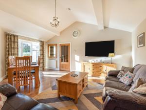 a living room with a couch and a table at Barn Owl Cottage in Wisbech