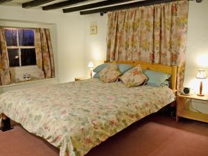 a bedroom with a large bed and two windows at Pats Cottage in Dore