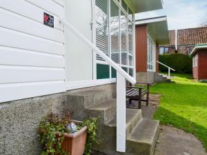 eine Veranda eines Hauses mit einer Treppe und einer Bank in der Unterkunft Poppy in Cromer