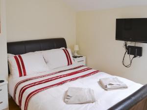 a bedroom with a bed with two towels on it at Oak Tree Barn - 27693 in Otterburn