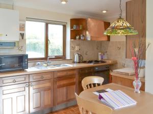 a kitchen with a table and a sink and a window at Champernowne in Darlington