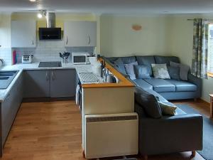 a kitchen and a living room with a couch at Trellee in Budock Water