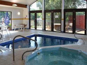 a large swimming pool in a house with a patio at Trellee in Budock Water