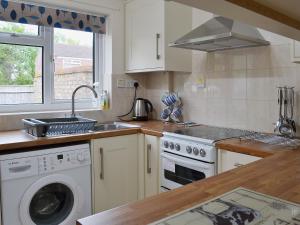 een keuken met een wastafel en een wasmachine bij Sea Breeze in Hopton on Sea