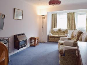een woonkamer met een bank en een televisie bij Sea Breeze in Hopton on Sea