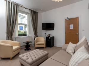 a living room with a couch and chairs and a window at Oddicombe, Torquay in Torquay