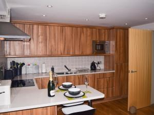 a kitchen with wooden cabinets and a white counter top at Chaucers Nook in Wigan