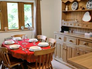 a dining room with a table with a red table cloth at Fell View in Kettlewell