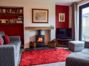 a living room with a fireplace and a tv at Fell View in Kettlewell