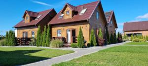 a house with a brown roof and a driveway at Domki La Plata in Łeba