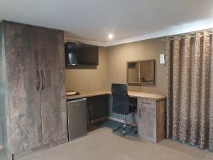 una oficina con escritorio y silla en una habitación en Mourice Lodge, en Sterkspruit