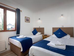 ロクサムにあるGrebeのベッドルーム1室(青い枕と窓付きのベッド2台付)