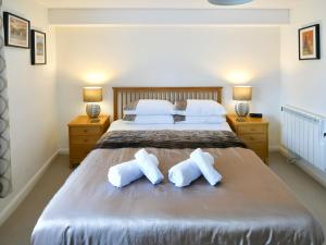 a bedroom with a large bed with two pillows at 5 Balmoral House in Keswick
