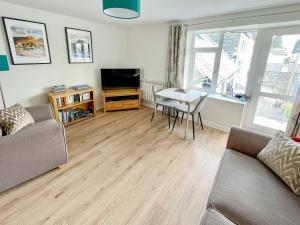 a living room with a couch and a table and a television at 5 Balmoral House in Keswick