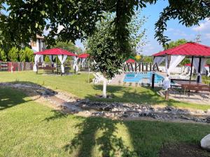 Guest House Misha في Petrevene: حديقة بها مسبح وطاولات للتنزه