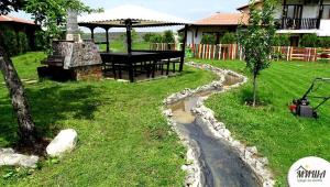 un jardín con una mesa y un camino de piedra en Guest House Misha, en Petrevene